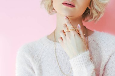 cropped shot of sensual young woman holding jewelry in hand isolated on pink clipart