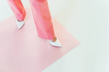 Kızın Grey pembe kağıt üzerinde duran pembe pantolon içinde kırpılmış atış