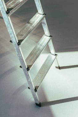 close-up view of metal stepladder in studio on grey      clipart