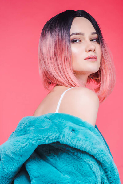 sensual girl with pink hair posing in blue fur coat, isolated on pink