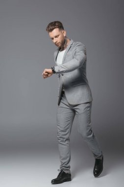 yakışıklı aceleyle işadamı izle, gri izole bakarak