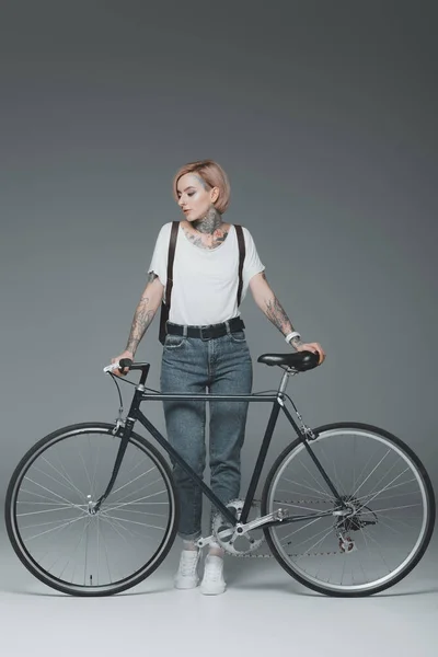 Όμορφο Κομψό Κορίτσι Τατουάζ Μόνιμη Ποδήλατο Που Απομονώνονται Γκρι — Φωτογραφία Αρχείου