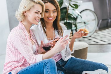 şarap ve smartphone kullanarak pizza güzel kadınlarla