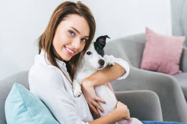 gülümseyen kadın ile jack russell terrier köpek evde koltukta oturan