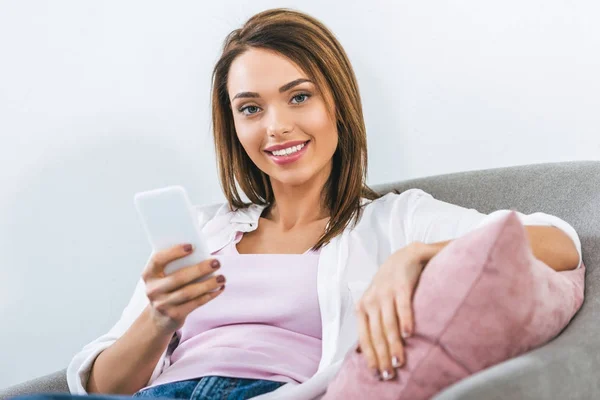 Fröhliche Schöne Frau Mit Smartphone Und Sessel — kostenloses Stockfoto