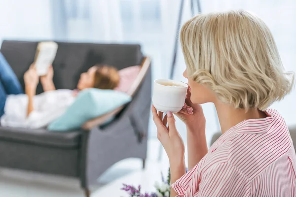 Blond Kvinna Dricker Kaffe Medan Hennes Vän Avkopplande Bakom — Stockfoto