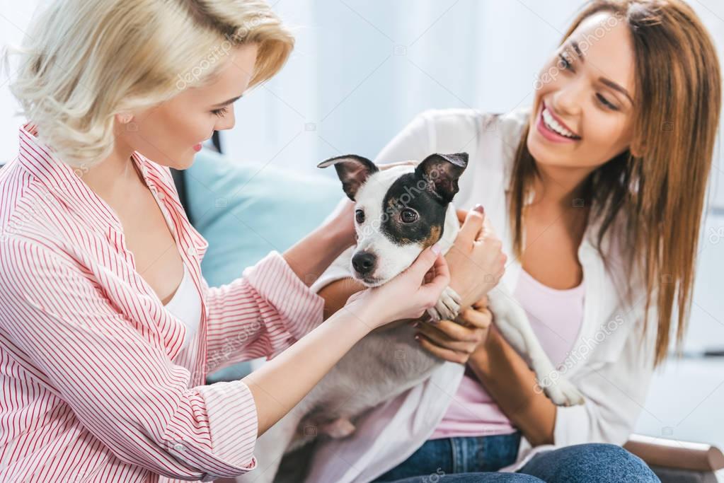 happy girls with jack russell terrier dog at home