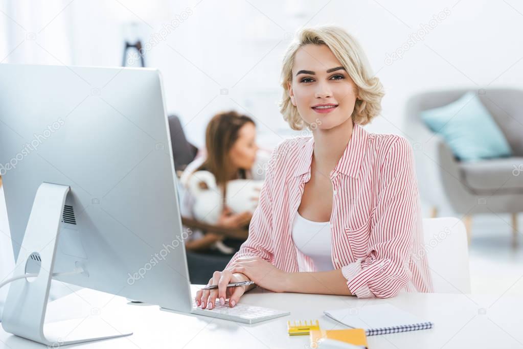 beautiful blonde girl working with computer at home