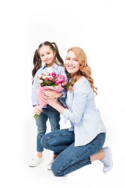 Anne ve küçük kızı beyaz izole buket ile gülümseyen, anneler günü kavramı