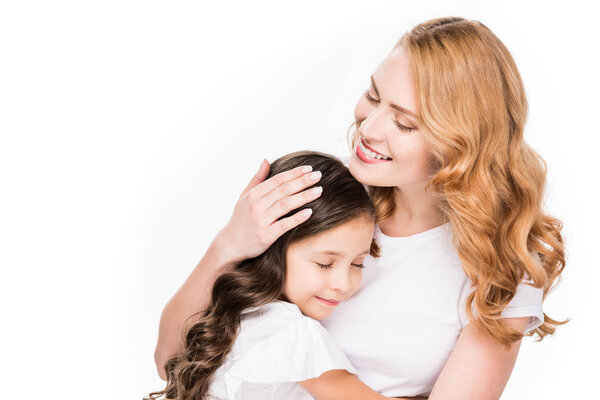 portrait of smiling mother hugging daughter isolated on white