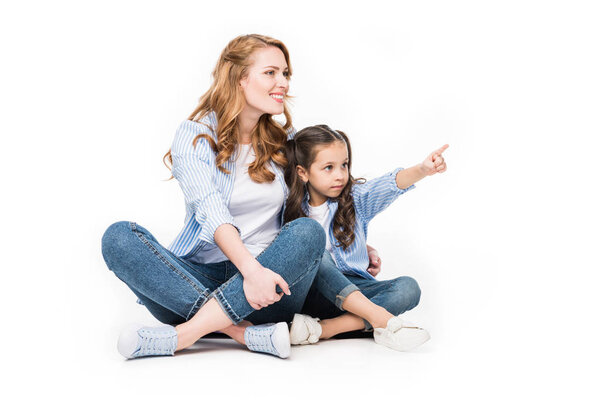 child pointing away while showing something to mother isolated on white