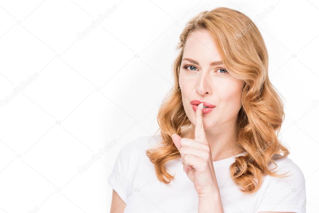 portrait of attractive woman showing silence sign isolated on white