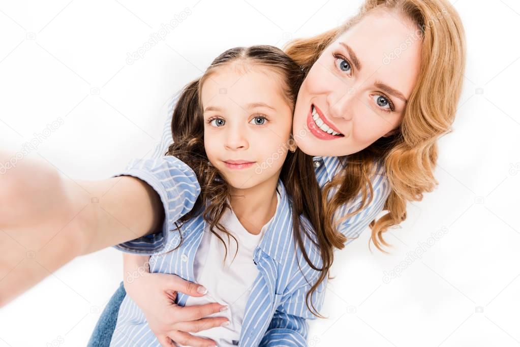 camera point of view of mother and daughter taking selfie together isolated on white