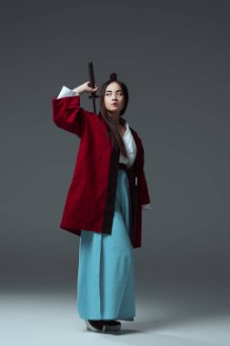 samuray katana kılıcı tutan ve uzak gri görünümlü kimono içinde görünümünü tam uzunlukta