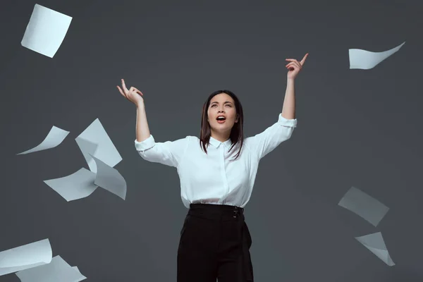 Emotionale Junge Geschäftsfrau Wirft Papiere Isoliert Auf Grau — Stockfoto