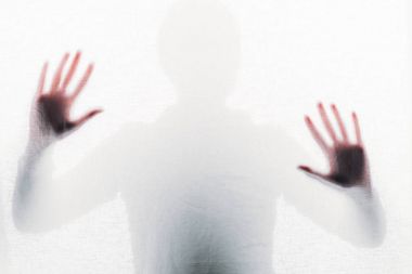 blurry silhouette of person touching frosted glass with hands clipart