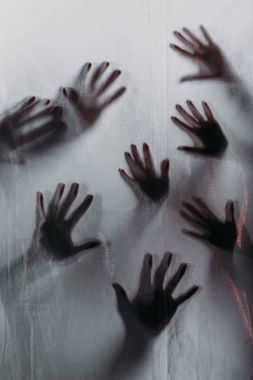 blurry scary silhouettes of human hands touching frosted glass clipart