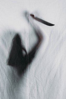scary blurry silhouette of person holding knife behind veil clipart