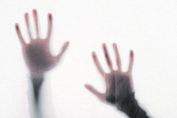 blurry silhouette of human hands touching frosted glass