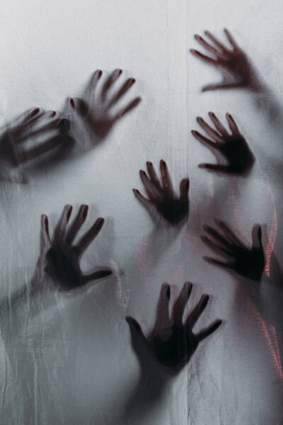 blurry scary silhouettes of human hands touching frosted glass