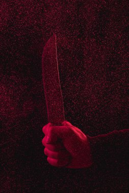 cropped shot of man holding knife in red light  clipart