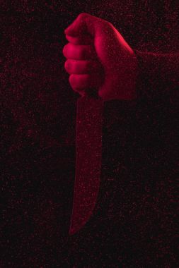 close-up partial view of man holding knife in red light clipart