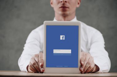 shot dijital tablet facebook web sitesi ile ekranda tutan adamın kırpılmış