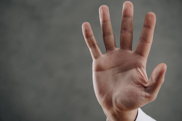 close-up partial view of human palm on grey