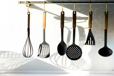 close-up view of various utensils hanging in kitchen  clipart