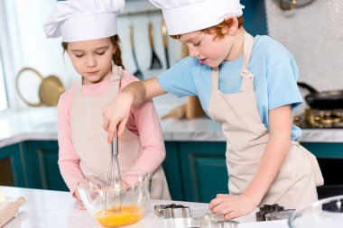 Kardeşler chef şapka ve hamur mutfakta çırpma önlük