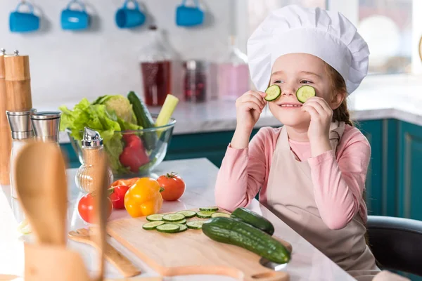 Niño Sombrero Chef Delantal Sosteniendo Rebanadas Pepino Mientras Cocina Cocina —  Fotos de Stock