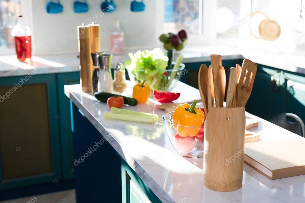 close-up view of wooden utensils, fresh vegetables and spices on kitchen table