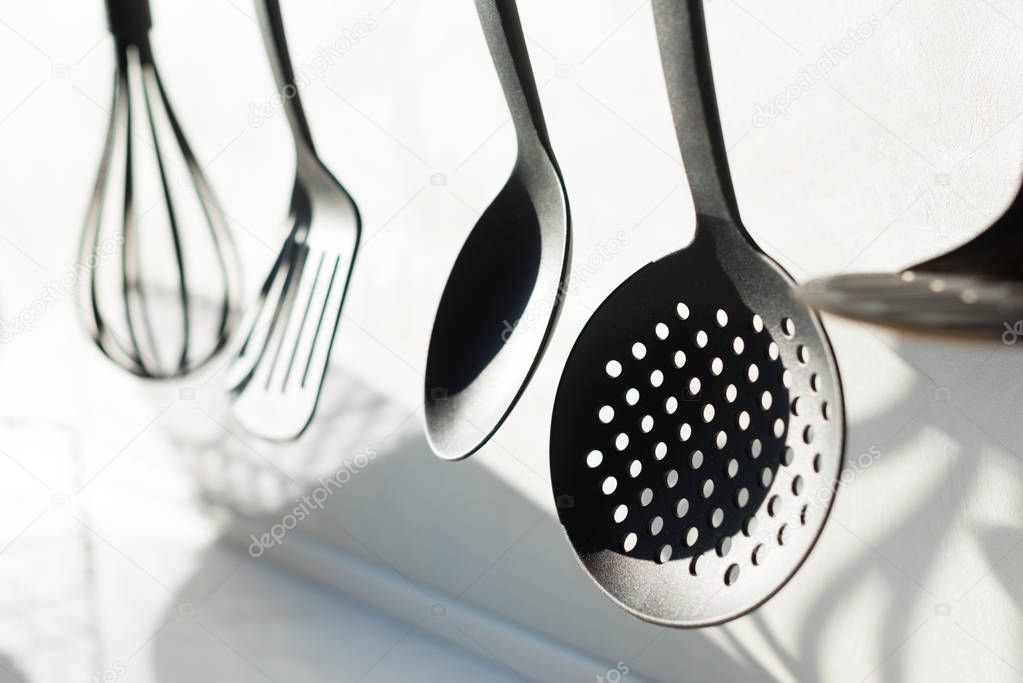 close-up view of various utensils hanging in kitchen 