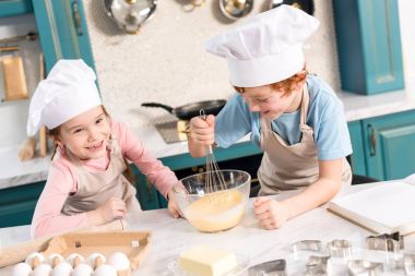 mutlu küçük chef şapka ve hamur mutfakta çırpma önlük çocuklar