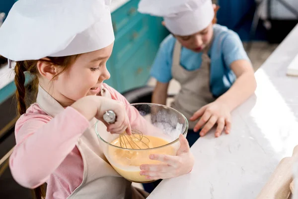Criança Pequena Bonito Chapéu Chef Fazendo Massa Enquanto Irmão Sentado — Fotografia de Stock