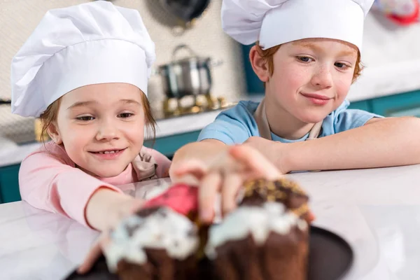 Mosolygó Kis Gyermekek Nézett Finom Cupcakes Előtérben Szakács Sapka — Stock Fotó