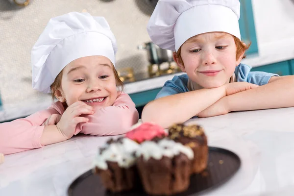 Crianças Felizes Chapéus Chef Olhando Para Deliciosos Cupcakes Primeiro Plano — Fotografia de Stock