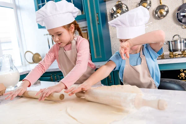 Kleine Kinder Kochmützen Und Schürzen Rollen Teig Der Küche — kostenloses Stockfoto