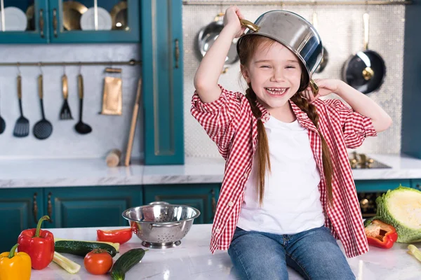 Lindo Niño Con Sartén Cabeza Divertirse Sentarse Mesa Cocina — Foto de Stock