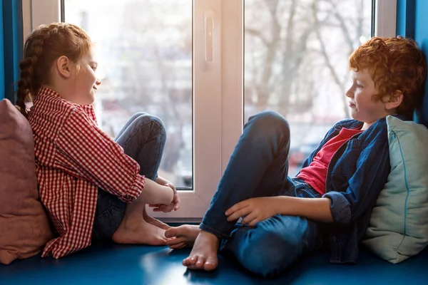 Söta Lilla Barn Leende Varandra Medan Sitter Fönsterkarm — Stockfoto