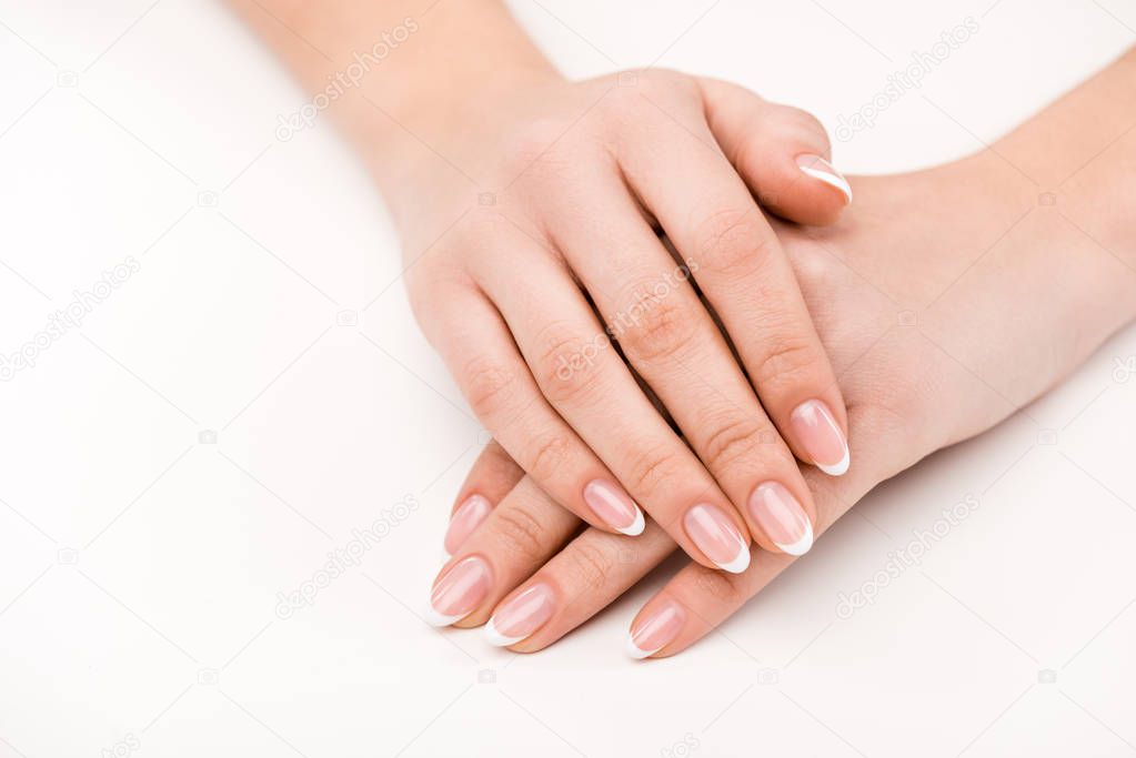 cropped view of female hands with natural manicure, isolated on white