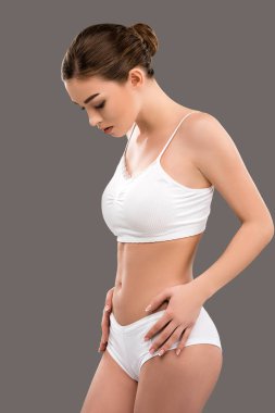 beautiful young woman posing in white underwear, isolated on grey clipart