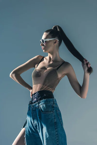 Trendy Model Poseren Zonnebril Met Paardenstaart Kapsel Geïsoleerd Grijs — Stockfoto