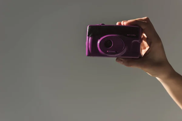 Corte Mão Feminina Segurando Câmera Foto Roxa Isolado Cinza — Fotografia de Stock