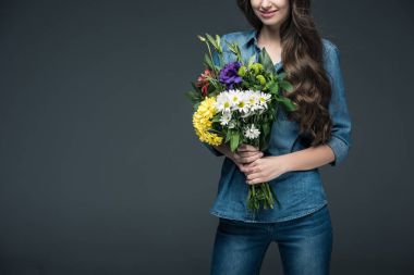 Uluslararası kadın günü için buket çiçek tutan denim giysileri gri izole kızı kırpılmış görünümünü