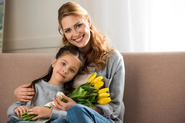 Feliz Madre Hija Con Tulipanes Amarillos Sentados Juntos Sonriendo Cámara —  Fotos de Stock