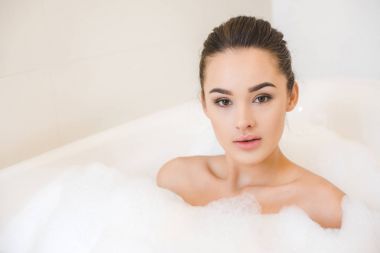 çekici genç kadın alarak banyo köpüğü vasıl ev ile portresi