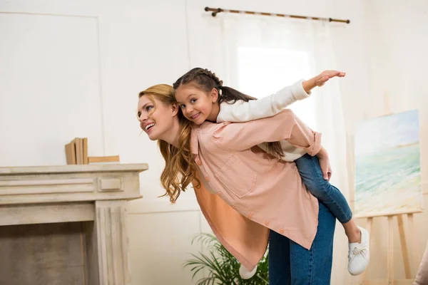 Feliz Madre Piggybacking Adorable Pequeña Hija Casa — Foto de Stock