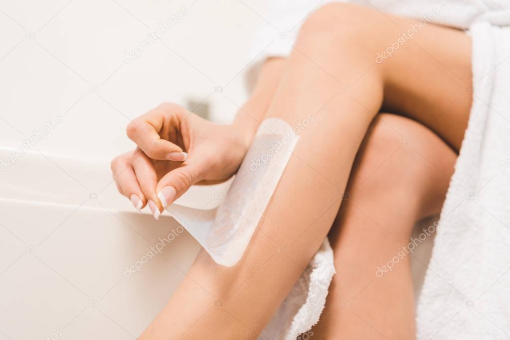 partial view of woman doing wax depilation at home