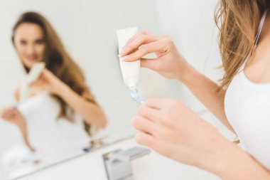 kadının elinde diş fırçası Diş macunu uygulayarak kısmi görünümü